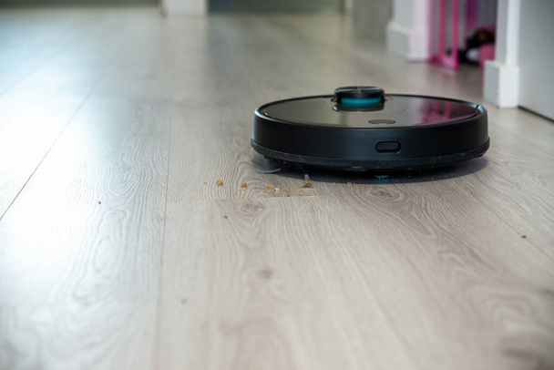 Robot vacuum cleaner is cleaning floor, close on dust - Фото, зображення
