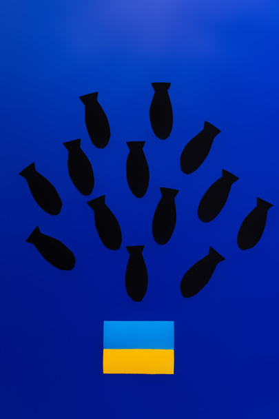 Top view of paper bombs above ukrainian flag on blue background  - Zdjęcie, obraz