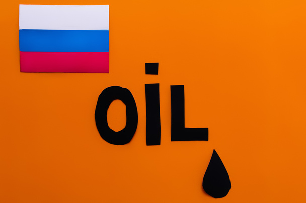 Draufsicht der russischen Flagge, Ölschrift und Papiertropfen auf orangefarbenem Hintergrund, Krieg in der Ukraine-Konzept  - Foto, Bild