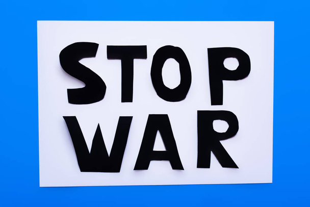 白と青の背景に停止戦争のレタリングのトップビュー  - 写真・画像
