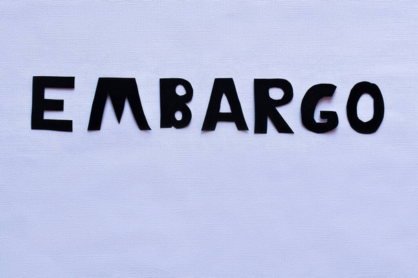 Draufsicht auf Embargo-Schriftzug auf weißem Hintergrund  - Foto, Bild