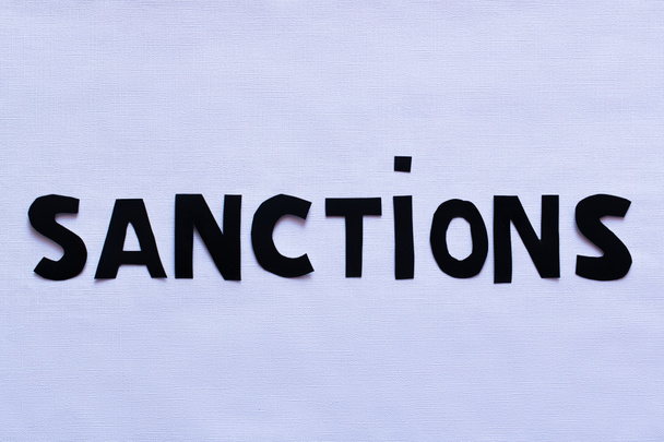 Top view of sanctions paper lettering on white background, war in ukraine concept  - Valokuva, kuva