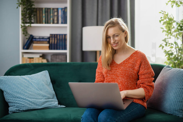 Woman with laptop on couch - Photo, image