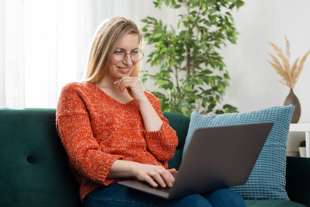 Woman on sofa with laptop - Zdjęcie, obraz