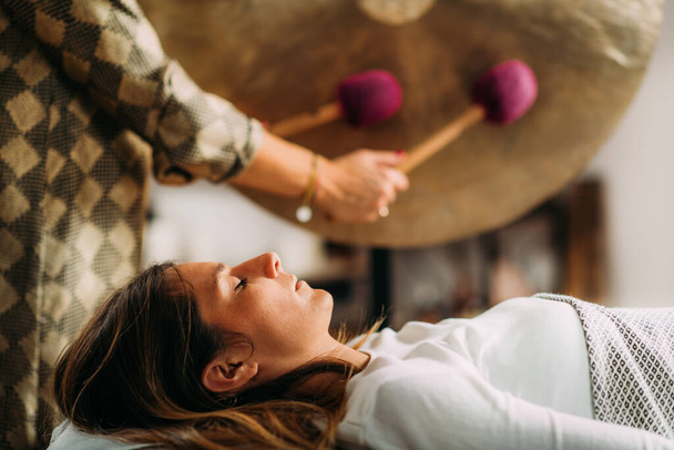 vrouw spelen gong in geluid bad therapie   - Foto, afbeelding