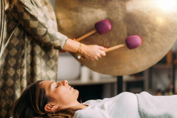 Nainen pelaa gong ääni kylpy paranemista terapia   - Valokuva, kuva