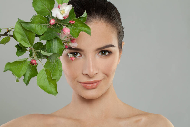 Lindo rosto. Perfeito jovem mulher close-up retrato. Modelo feminino com flores de maçã primavera - Foto, Imagem