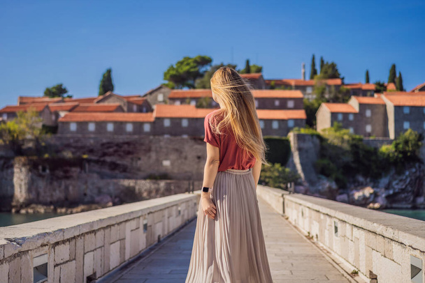 Woman tourist on background of beautiful view of the island of St. Stephen, Sveti Stefan on the Budva Riviera, Budva, Montenegro. Travel to Montenegro concept - Photo, Image