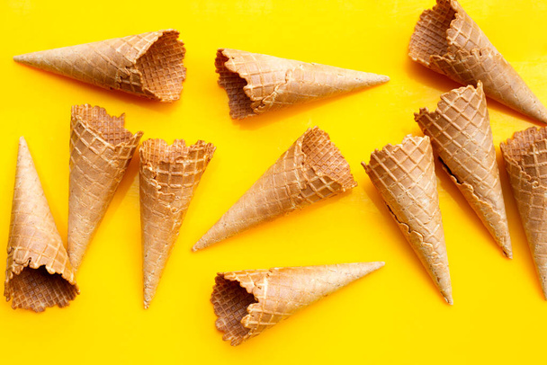 Empty ice cream cone on yellow background. - Photo, Image