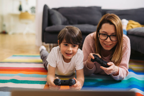 mother and son are playing video games at home - Φωτογραφία, εικόνα
