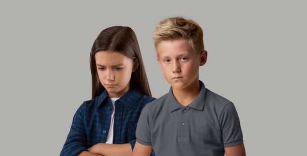 Koncept negativních emocí. Portrét rozrušené předpuberťáci děti pózování přes šedé pozadí - Fotografie, Obrázek