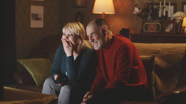 Wesoła para w podeszłym wieku śmieje się podczas przedstawienia - Zdjęcie, obraz