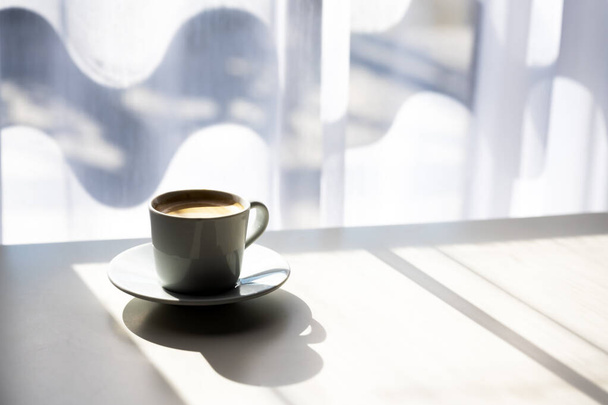 Espresso coffee cup on table near window - Fotó, kép