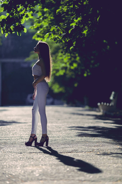 Beautiful girl in central park. All in white style. - Zdjęcie, obraz
