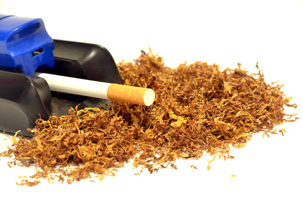 Montón de tabaco y una máquina para fabricar cigarrillos
 - Foto, imagen