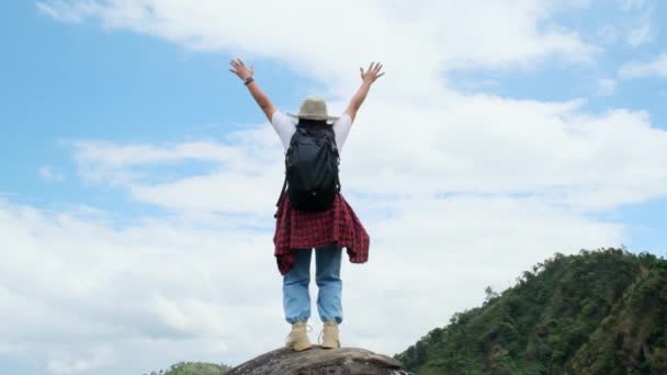 Kırmızı yağmurluklu genç Asyalı yürüyüşçü kadın dağın tepesinde kollarını kaldırıp manzaranın tadını çıkarıyor. yolculuk ve başarı kavramı - Video, Çekim