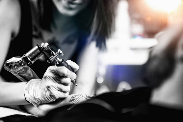 Tatuaje femenino profesional trabajando en un estudio de tatuajes - Foto, Imagen