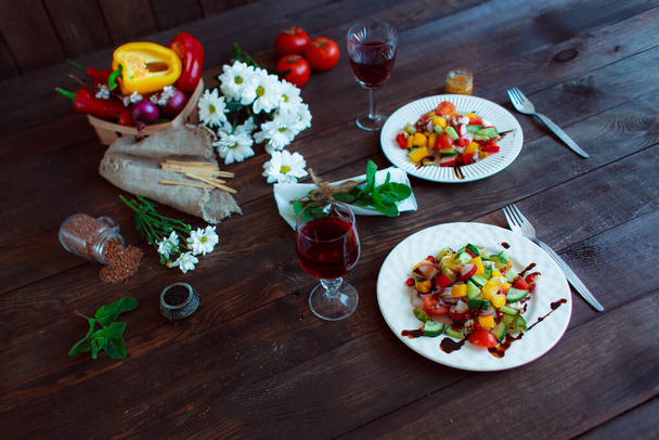 Spring vegetable salad. Still life of daisies, a glass of wine fresh pepper, herbs and cutlery. - Photo, image