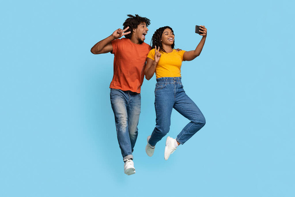 Mutlu Afrikalı Amerikalı aşıklar mavi ile selfie çekiyorlar. - Fotoğraf, Görsel