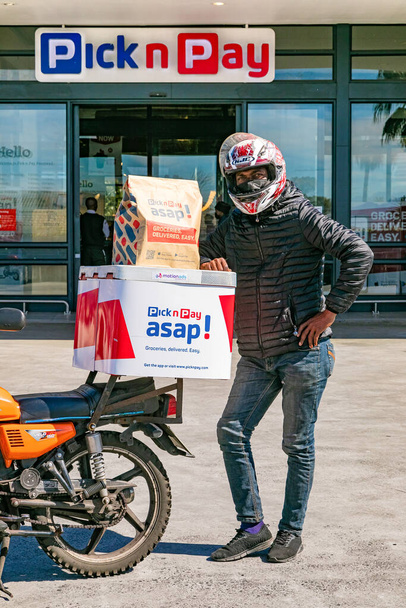 Cape Town, South Africa - September 9, 2021: Express Service delivery man with bike outside local Pick n Pay grocery store - Фото, зображення