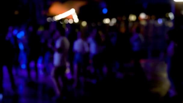 Açık hava kulübünde renkli ışıklarla dans eden bir grup insan. Partide dans edip eğlenmek. Odaklan ve kasıtlı olarak bulanık yap - Video, Çekim