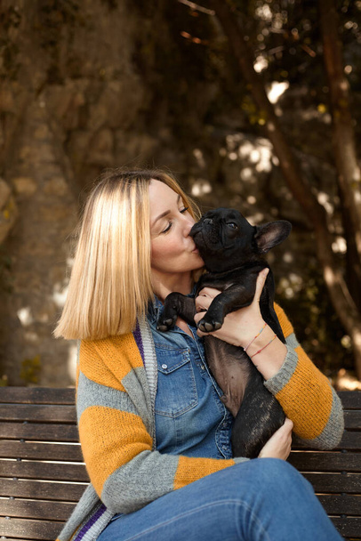 happy young woman with french bulldog dog sitting on a bench outdoor - Φωτογραφία, εικόνα