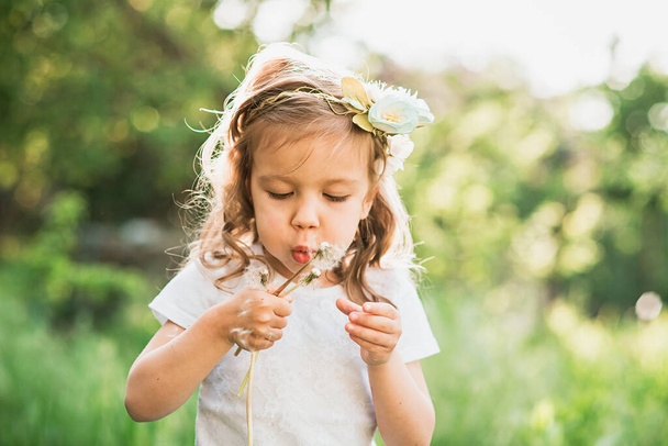 girl blowing dandelions flower selective focus. Allergy season. - Fotó, kép