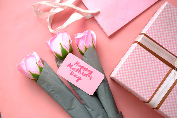  regalo del día de la madre y color rosa rosa flor en la mesa. - Foto, imagen