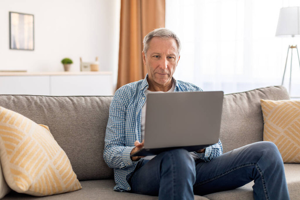 Confident casual mature using laptop at home - Foto, imagen