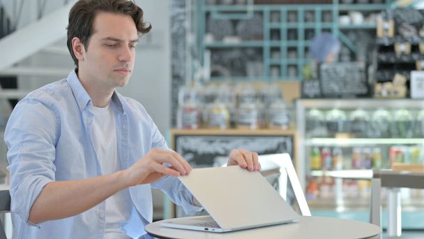Hombre creativo cerrando la computadora portátil desapareciendo en el Café  - Foto, Imagen