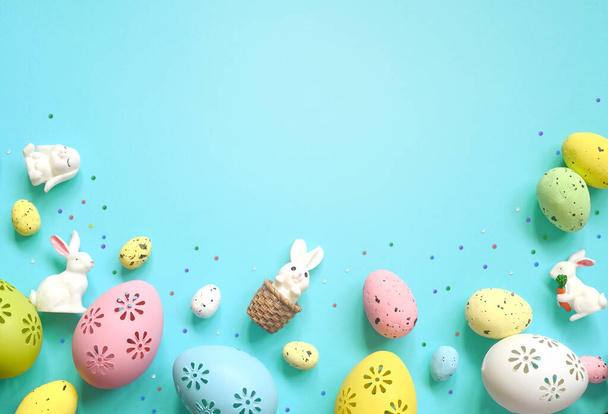 Composición de Pascua. Huevos de Pascua y conejito de Pascua sobre fondo azul pastel. Concepto mínimo de Pascua. Plano, vista superior, espacio para copiar - Foto, imagen