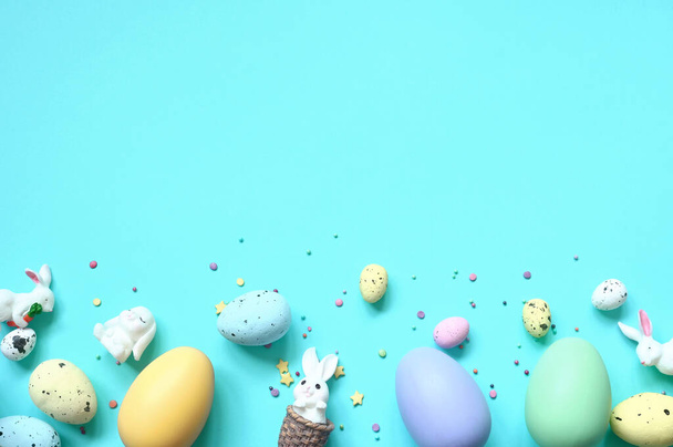 Easter composition. Easter eggs and easter bunny on pastel blue background. Minimal concept of Easter. Flat lay, top view, copy space - Fotografie, Obrázek