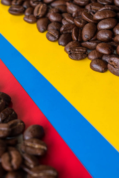 Μαύροι κόκκοι καφέ σε φόντο κολομβιανής σημαίας - Φωτογραφία, εικόνα