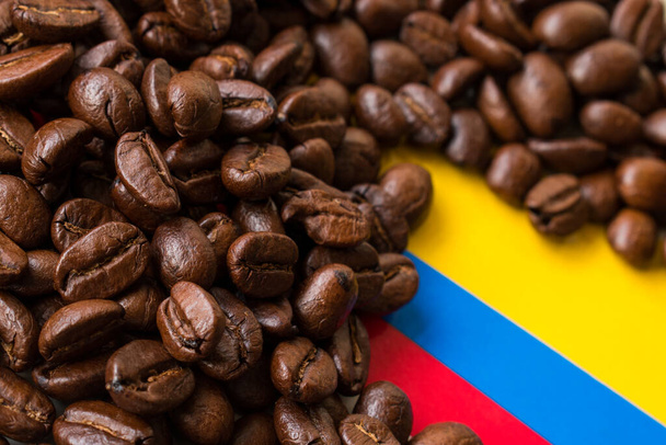 Algunos granos de café negro sobre fondo de bandera colombiana - Foto, imagen