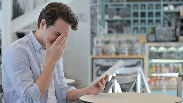 Homme créatif réagissant à la perte sur tablette dans Cafe  - Photo, image