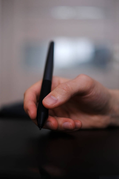 young designer holding a graphic tablet pen close-up - Photo, Image