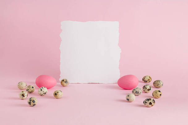 Easter concept with eggs and paper note on pastel pink background. Creative Easter holiday concept. Minimal festive or holiday greeting card. - Fotografie, Obrázek
