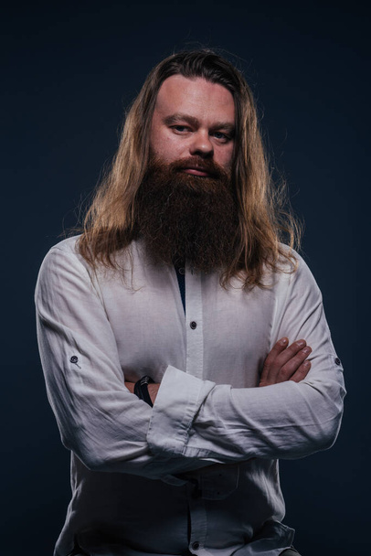 Közelkép portré jóképű férfi szakállas pózol stúdióban egy elszigetelt háttér. - Fotó, kép