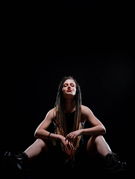 Portrait of a beautiful stylish girl wearing black dress isolated on black wall - Φωτογραφία, εικόνα