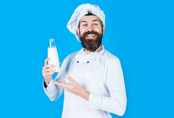 Cuoco barbuto che presenta latte in bottiglia o frullato. Prodotti lattiero-caseari. Dieta proteica. Yogurt senza lattosio. - Foto, immagini