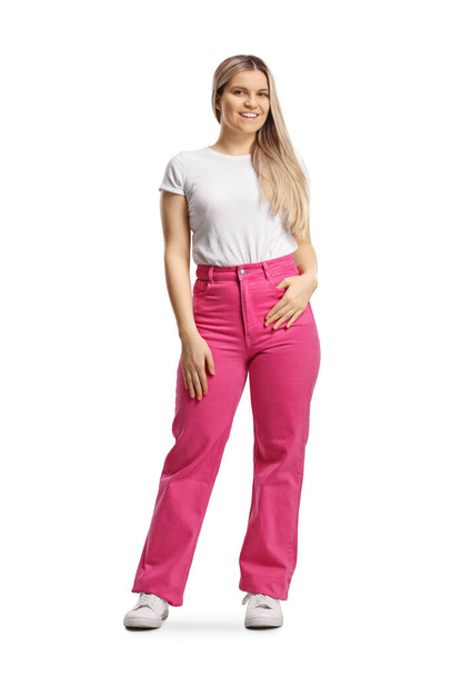 Full length portrait of a young woman in pink jeans posing isolated on white background - Foto, Imagem