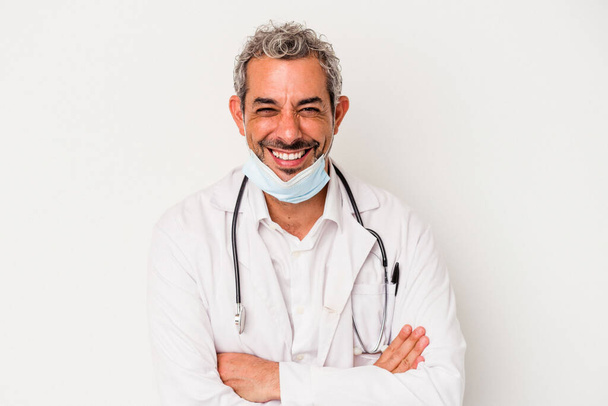 Keski-ikäinen lääkäri mies yllään naamio viruksen eristetty valkoisella taustalla nauraa ja hauskaa. - Valokuva, kuva