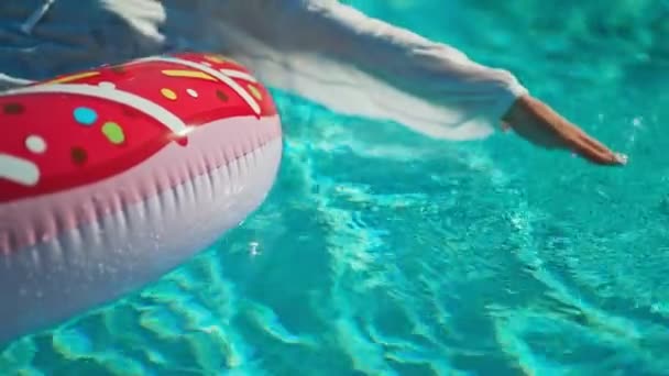 Mujer flota en anillo inflable en la piscina. Concepto vacaciones de verano. - Metraje, vídeo