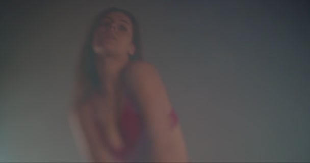 Cool dívka v podprsenka a džíny pohybující se svůdně, zpomalený pohyb, mělká hloubka pole, selektivní zaměření, obklopen kouřem - Záběry, video