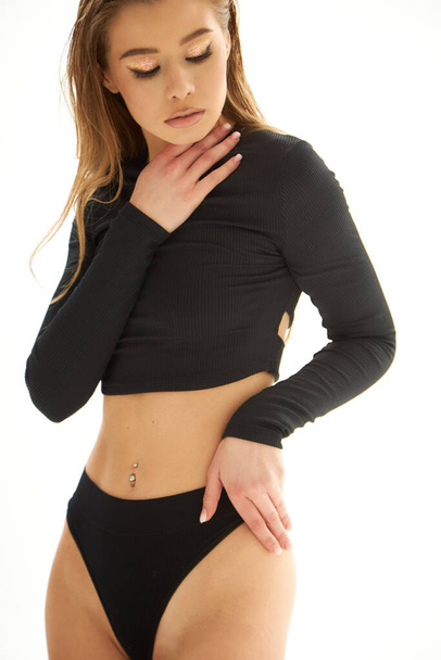 Happy young strong sporty athletic sportswoman in black sportswear. The concept of a beautiful elegant figure, body positive, healthy lifestyle. Slim tanned female body. Isolated on a white background. - Zdjęcie, obraz