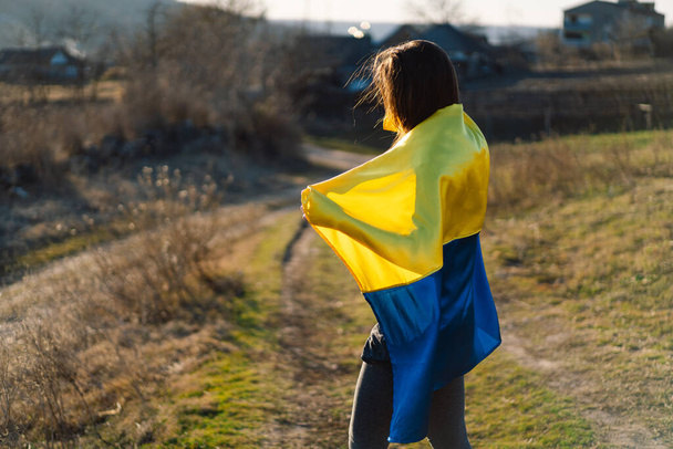Woman holding a yellow and blue flag of Ukraine in outdoors - Fotoğraf, Görsel