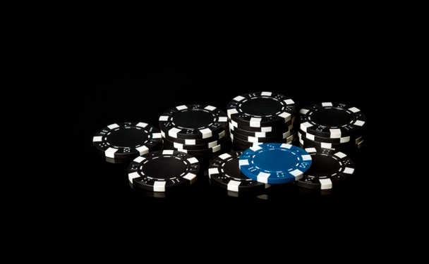 Chip neri ottenuti come risultato della vincita e uno blu. Una combinazione di successo nel casinò. Fortuna o fortuna in un poker club - Foto, immagini