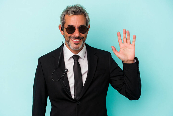 Middle age bodyguard caucasian man isolated on blue background  smiling cheerful showing number five with fingers. - Photo, Image