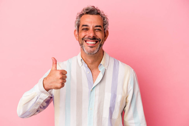 Middle age caucasian man isolated on pink background  smiling and raising thumb up - 写真・画像