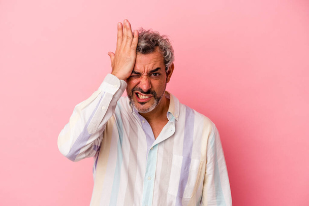 Middle age caucasian man isolated on pink background  forgetting something, slapping forehead with palm and closing eyes. - Фото, изображение